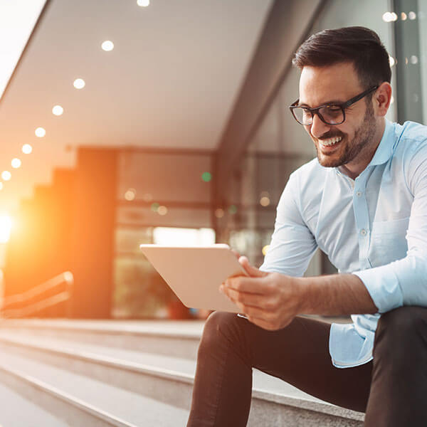 man smiling looking at tablet